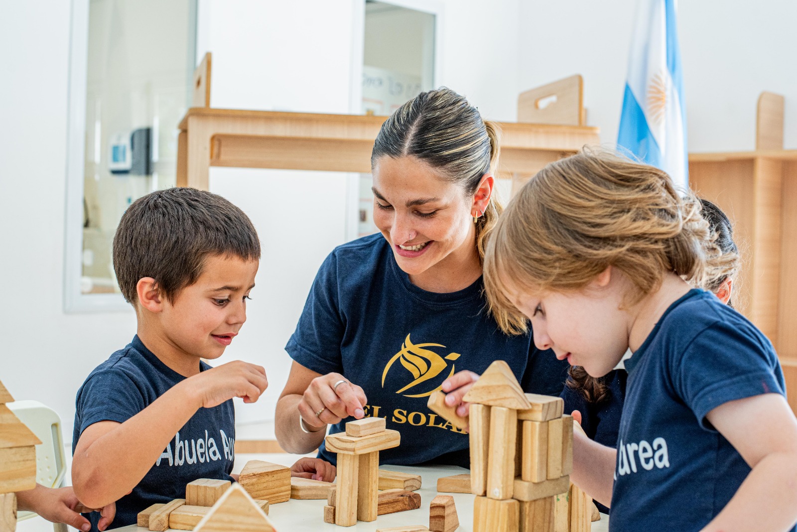 Docente acompañando a alumnos en una actividad de mesa